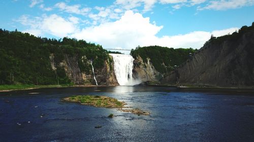 Scenic view of waterfall against sky