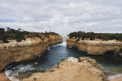 Wide angle view of  loch ard gorge by ocean against sky