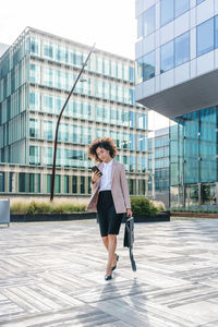 Full length of young woman standing in city