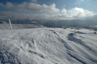 Scenic view of snow covered land against sky