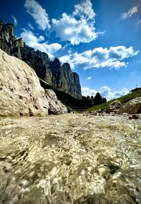 Surface level of rocks on shore against sky
