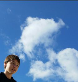 Low angle view of woman standing against blue sky