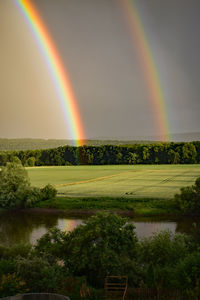 Scenic view of rainbow over landscape against sky
