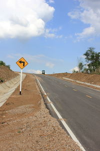 Road sign against sky