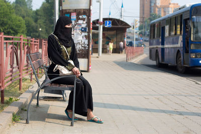 A muslim woman in a national outfit walks around an unfamiliar european city after emigrating.