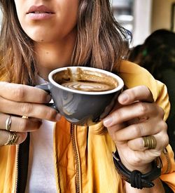 Midsection of woman drinking coffee