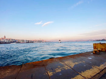 Scenic view of sea against buildings during sunset