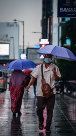 People walking on wet street during monsoon