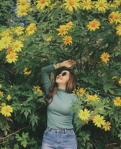 Woman standing by flowering plants