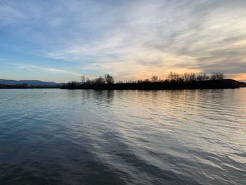 Scenic view of lake against sky at sunset