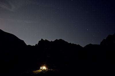 Silhouette mountains against sky at night