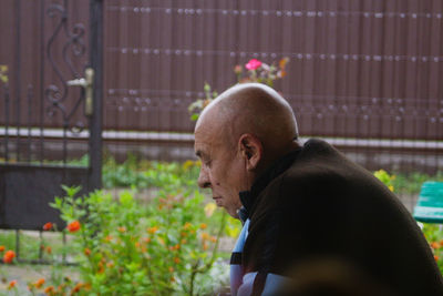 Portrait of a senior bald man outdoors. 70s years old latin or hispanic man standing outside 