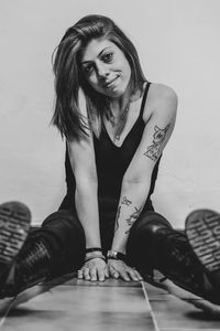 Portrait of young woman sitting on floor