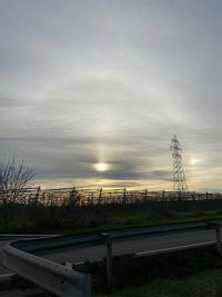 Electricity pylon on field against sky during sunset