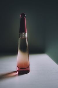 Close-up of glass bottle on table against black background