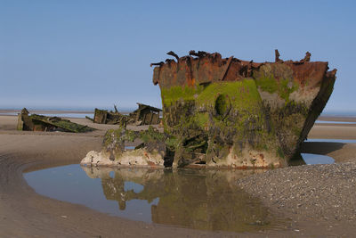 Old ruin on beach against clear sky