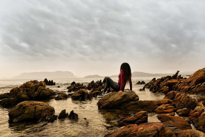 Rear view of woman looking at sea against sky