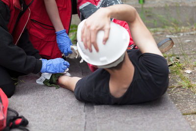 Paramedics treating male worker fallen on road