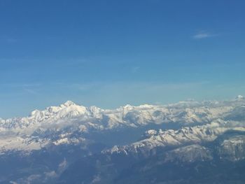 Scenic view of snowcapped mountains against blue sky