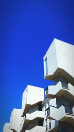 Low angle view of modern building against blue sky