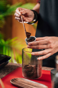 Midsection of man holding ice cream on table