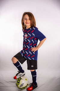 Portrait of smiling girl standing against wall