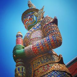 Low angle view of colorful temple against clear blue sky