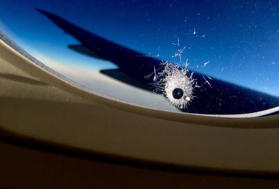 Close-up of airplane swimming in sea against blue sky