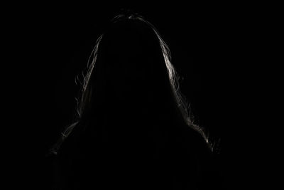 Portrait of woman against black background