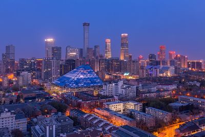 Illuminated buildings in city against sky at night