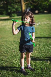 Portrait of a beautiful caucasian girl blows soap bubbles standing in the park