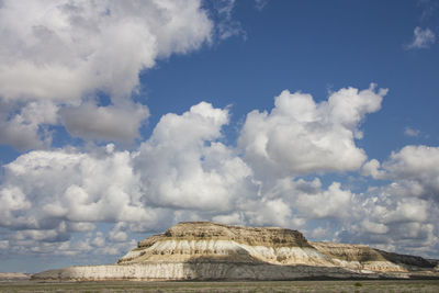 Low angle view of rocks against cloudy sky