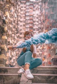 Full length of girl sitting against wall