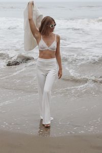 Rear view of woman standing at beach