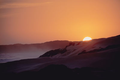 Scenic view of silhouette mountains against sky during sunset