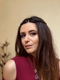 Portrait of smiling young woman against wall.