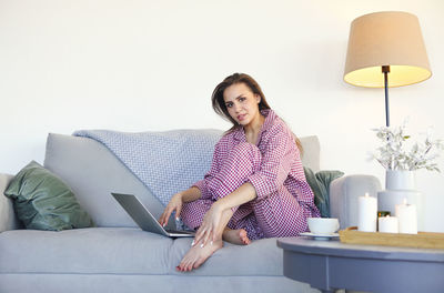 Portrait of woman sitting on sofa at home