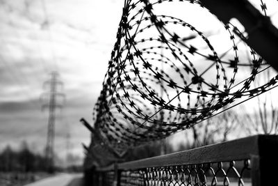 Close-up of metal fence against sky