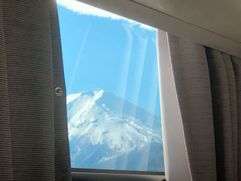 Close-up of snow covered mountain seen through glass window