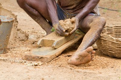 Close-up of man working on sand