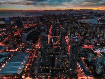 High angle view of city lit up at sunset