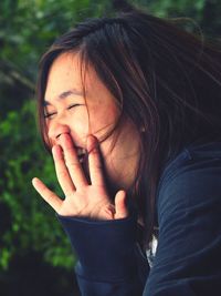 Close-up of cheerful woman with eyes closed