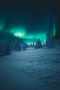 Scenic view of snowcapped landscape against sky at night