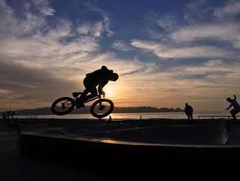 Silhouette of people at park during sunset