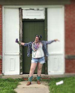 Full length of woman standing against building