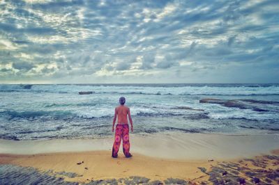 Scenic view of beach against cloudy sky