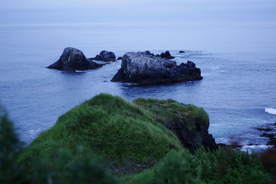 Scenic view of rocks in sea against sky