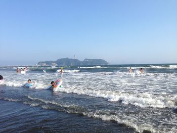 People surfboarding in sea