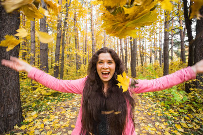 Portrait of smiling woman standing by plants during autumn