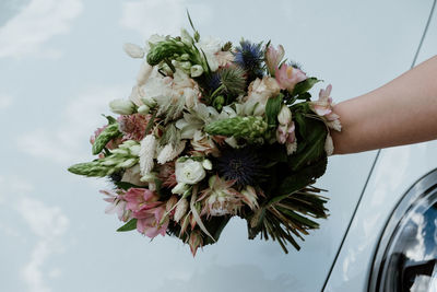 Midsection of woman holding bouquet of flowering plant